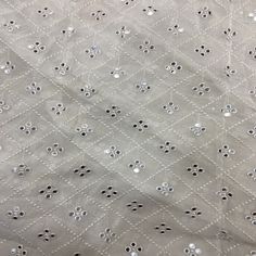 an old quilted fabric with silver sequins on it's edges and holes in the middle