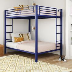 a blue bunk bed sitting in a bedroom next to a white book shelf filled with books