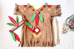 a child's native american outfit with scissors and thread