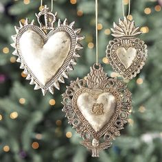 three heart ornaments hanging from a christmas tree