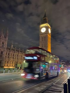 the big ben clock tower towering over the city of london at night with traffic passing by