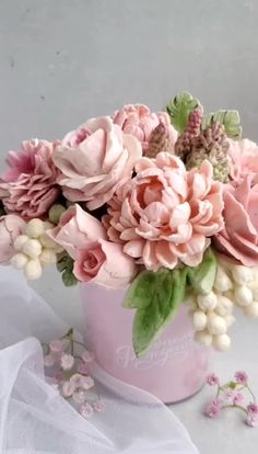 a pink vase filled with flowers on top of a table