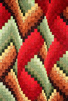 a close up view of a red and green quilted design on a table cloth