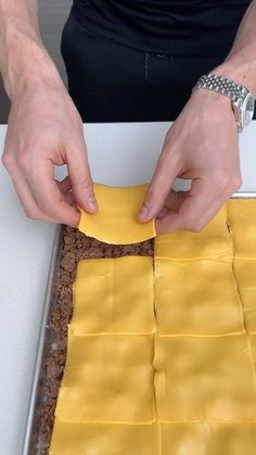 a person is making something out of yellow paper on a counter top with their hands