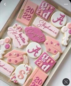 decorated cookies with pink and white icing in a box