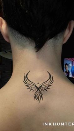 the back of a woman's neck with a bird tattoo on her left side