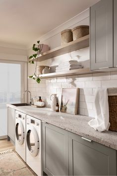 a washer and dryer sitting in a kitchen next to each other on top of a counter