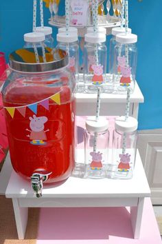 a table topped with jars and cups filled with liquid