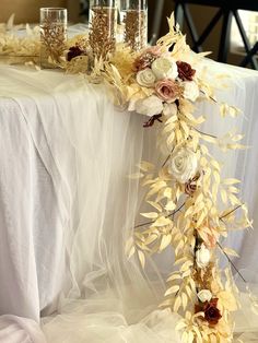 the table is decorated with flowers and gold leafy stems, along with champagne glasses