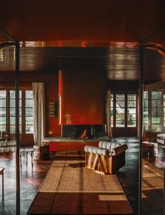 a living room filled with furniture and a fire place in the middle of it's walls