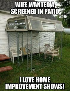 a chicken coop sitting in the grass with chairs around it and an advertisement on the door