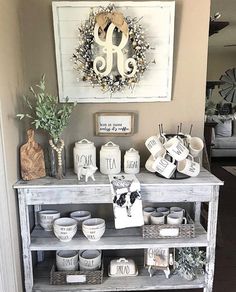 a shelf filled with dishes and cups on top of a wooden floor next to a wall