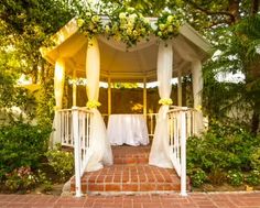 a gazebo decorated with flowers and white linens