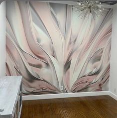 an artistic wall mural in a room with wood flooring and a chandelier hanging from the ceiling