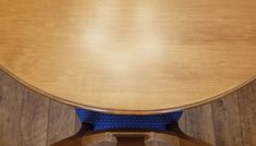 a wooden table with blue seat covers on it's back end and wood flooring