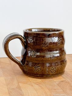 a brown mug sitting on top of a wooden table