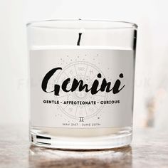 a candle with the word genni written in black on it sitting on a table