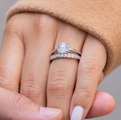 a woman's hand with a diamond ring on it