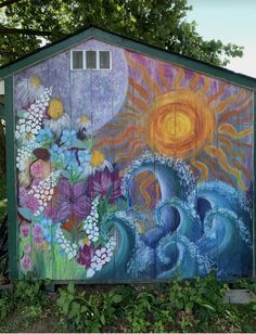 a painted shed with flowers and sun on it