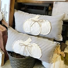 two decorative pumpkin pillows sitting on top of each other next to some boxes and crates