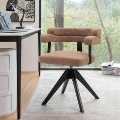 a brown office chair sitting on top of a wooden floor next to a desk and window