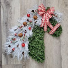 two christmas wreaths on the floor with bows and decorations