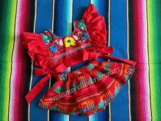 Serape birthday outfit, red mexican skirted bloomers, floral embroidered crop top, cotton ruffled sleeve top, taco twosday, red mexico dress This is a super cute Mexican outfit with a twist, the hand embroidered crop top it is beautiful, the ruffled sleeve, completely open on the sides and the tie bows, definitely gives the perfect touch to our original design. The outfit every girl will dream about Outfit includes: Floral embroidered crop top and skirted bloomers. Fits size 2T All our outfits are made with love and fits true to size. Care instructions: Wash by hand with cold water and hang to dry. * Visit the shop * https://www.etsy.com/shop/Miamorcitocorazon * Follow us on instagram * @miamorcitocorazonmx ------------------------------------------------------ I don't accept returns, exch Red Floral Embroidered Summer Sets, Red Sets For Summer Festival, Spring Red Ruffled Sets, Embroidered Red Summer Sets, Traditional Red Summer Sets, Red Cotton Sets For Festival, Traditional Red Sets For Summer, Traditional Red Set For Summer, Red Dress For Cinco De Mayo Fiesta