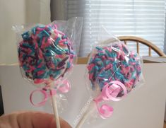 two lollipops with pink and blue sprinkles on them