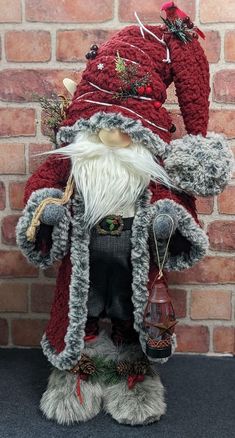 a santa clause figurine sitting next to a brick wall