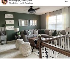 a living room filled with furniture next to a white stair case in front of a window