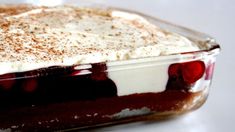 a dessert dish with whipped cream and cherries in it on a white counter top