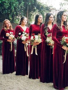 a group of women standing next to each other holding bouquets and wearing red dresses