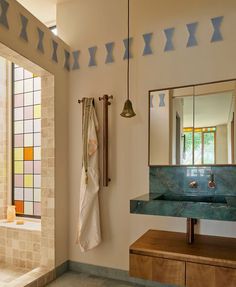 a bathroom with a sink, mirror and towel rack