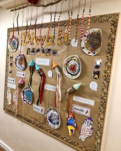 a bulletin board with many different items hanging on it's sides and pinned to the wall