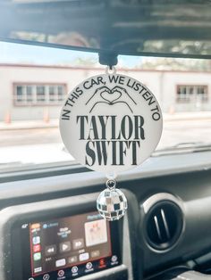 the interior of a car with a taylor swift sign hanging from it's dash