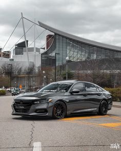 a gray car parked in front of a large building