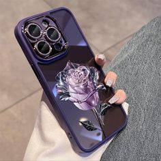 a woman's hand holding an iphone case with a purple rose and sunglasses on it