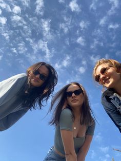 three young women are standing in the sun