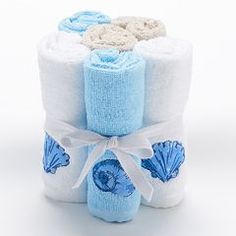 a stack of blue and white towels with seashells on them