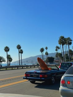 there is a surfboard sticking out of the back of a car's trunk