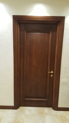 an empty room with a wooden door and tiled floor