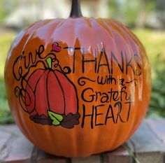 a painted pumpkin sitting on top of a wooden block