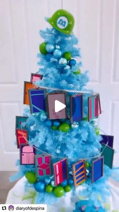 a blue christmas tree decorated with pictures and ornaments