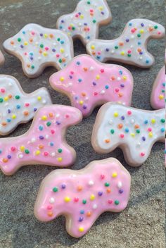 several decorated cookies with sprinkles are on the ground next to each other