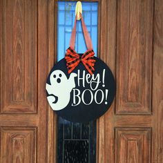 a door hanger that says hey boo with a ghost on it's front