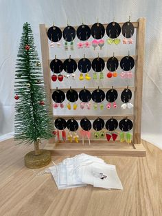 an assortment of earrings on display next to a small christmas tree