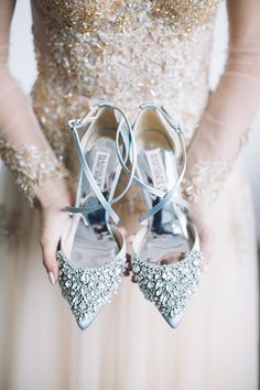 a bride holding her wedding shoes in front of her