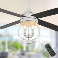 a white ceiling fan with two lights and remotes hanging from it's blades