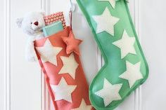 two christmas stockings hanging on a door with a teddy bear in the stocking next to them