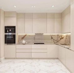 a kitchen with marble counter tops and white cabinets, along with an oven on the wall